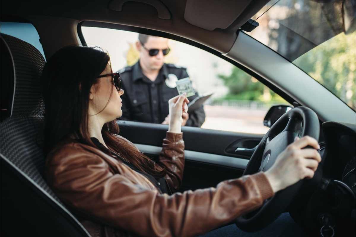 A woman handing ID to a police officer at a traffic stop near Lexington, Kentucky (KY)