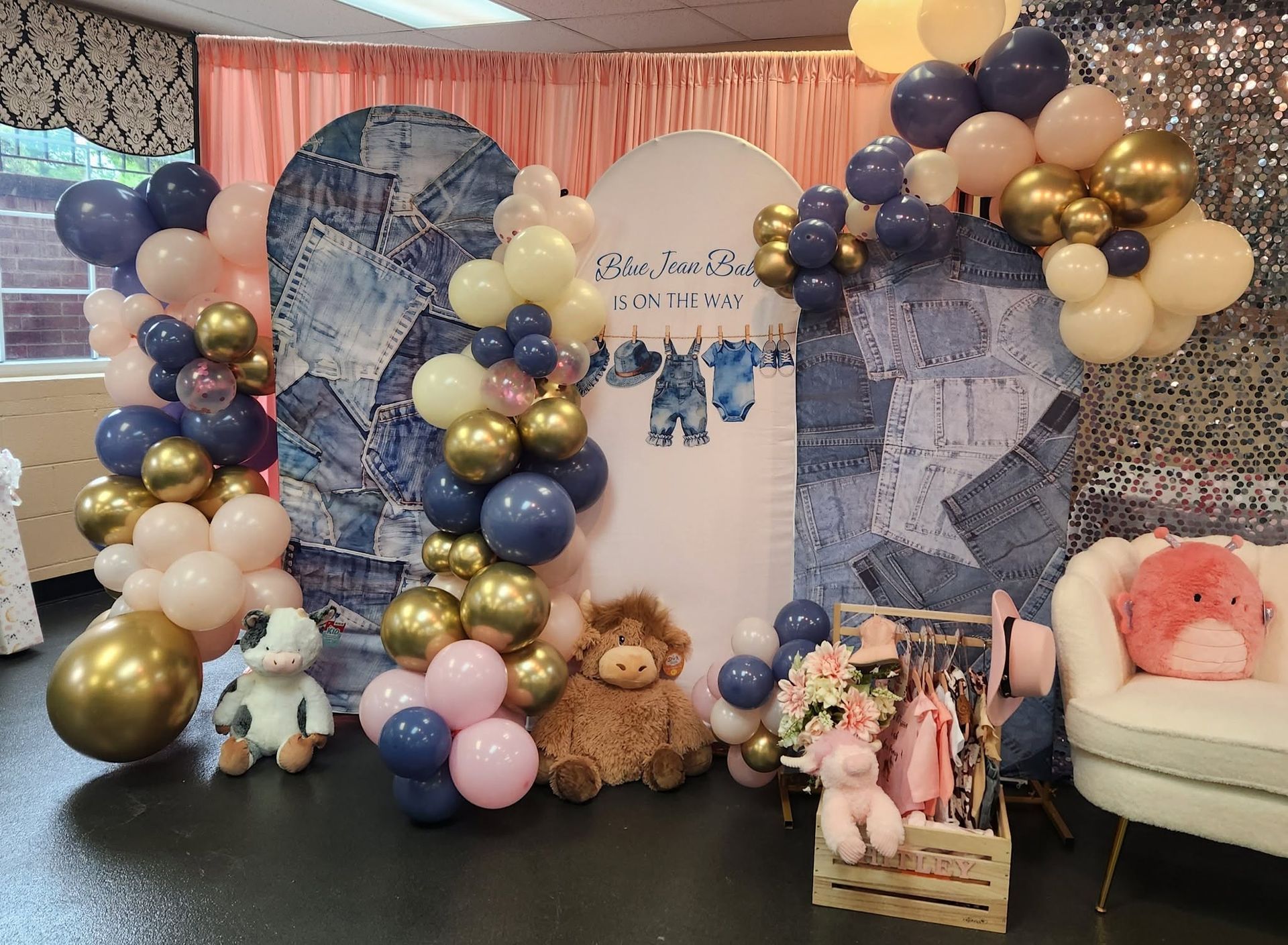Pastel and gold balloon backdrop with teddy bears and floral accents at a baby shower setup