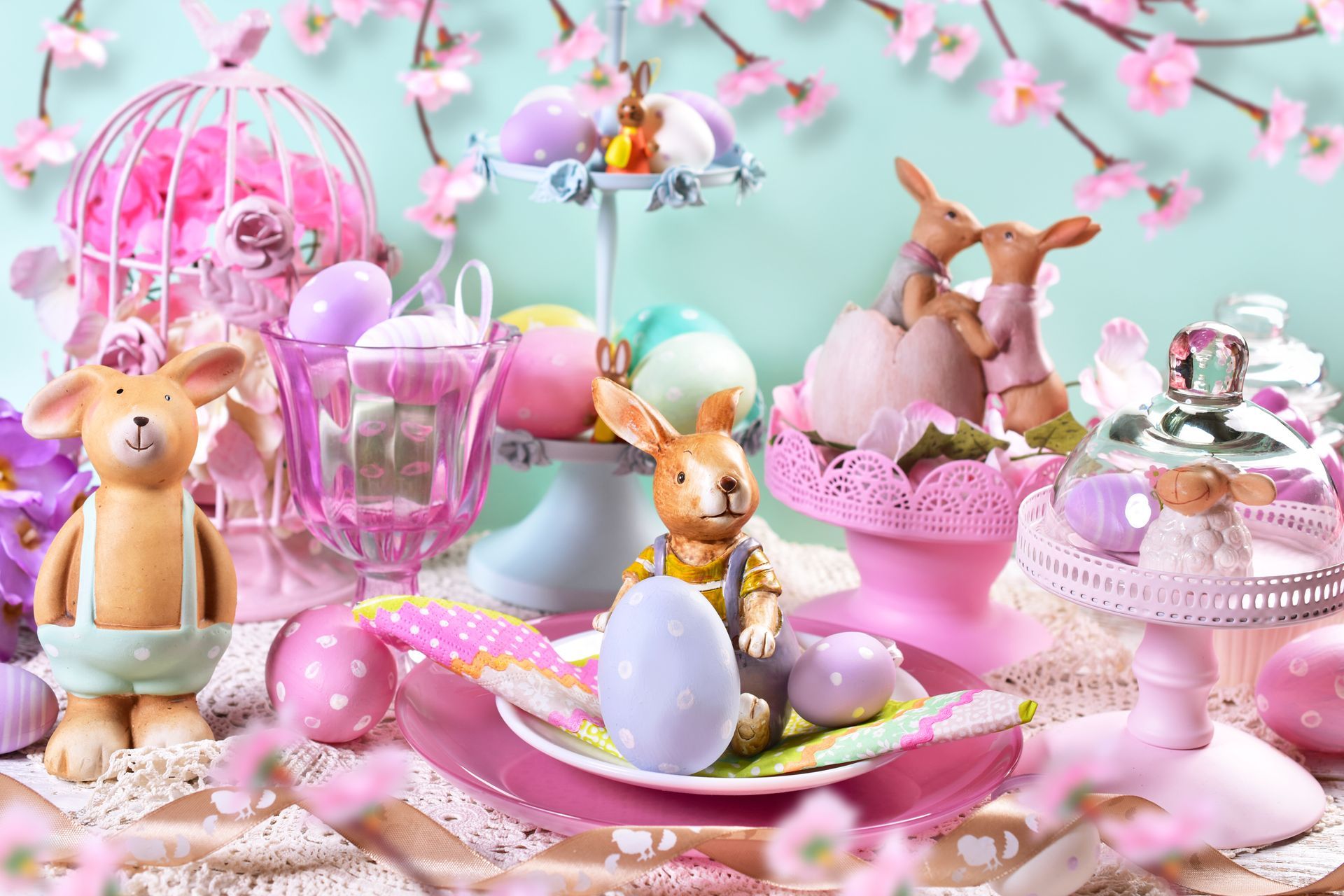 Pastel toy Easter display with bunny figurines, eggs, cupcakes, and pink tea party decorations