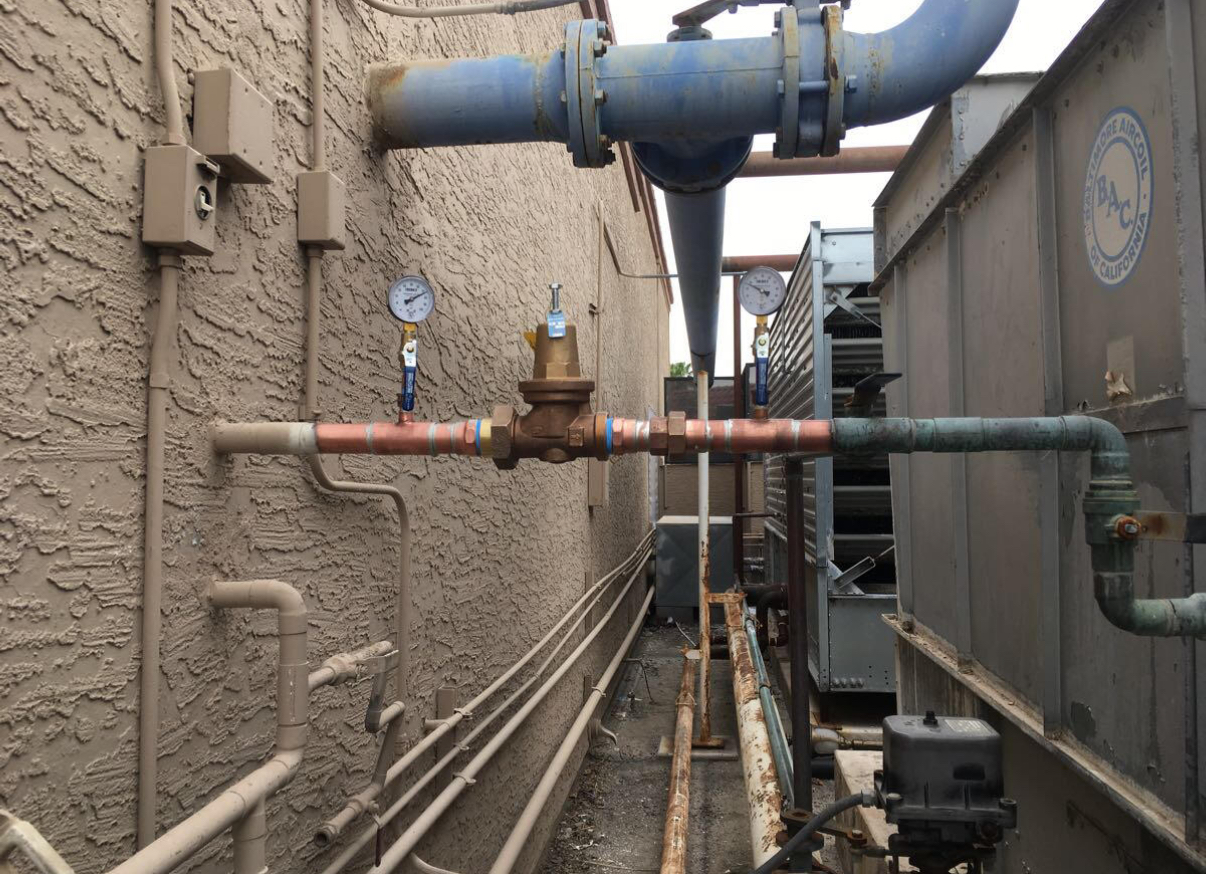 A bunch of pipes are connected to each other on the side of a building.