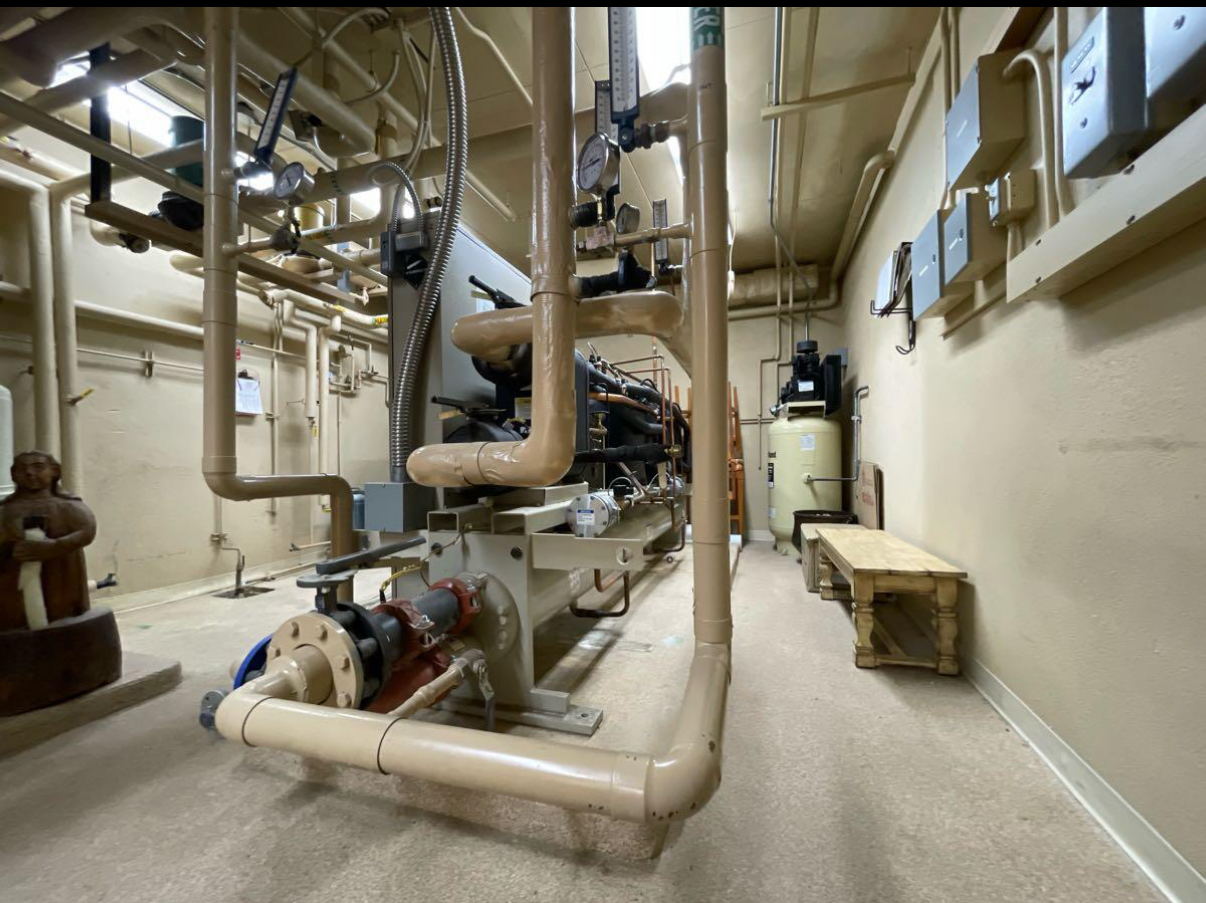 A room with a lot of pipes and a bench