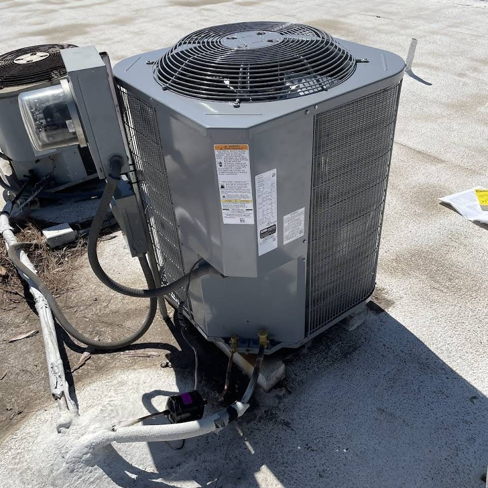 A large air conditioner is sitting on a concrete surface.