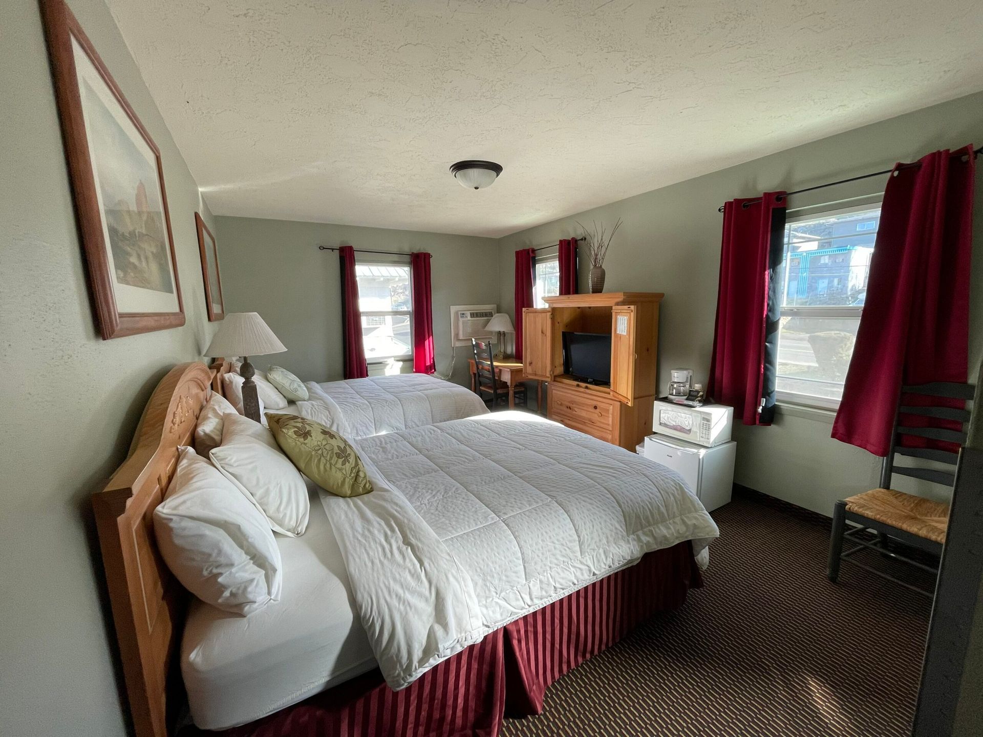A hotel room with two beds and a television.