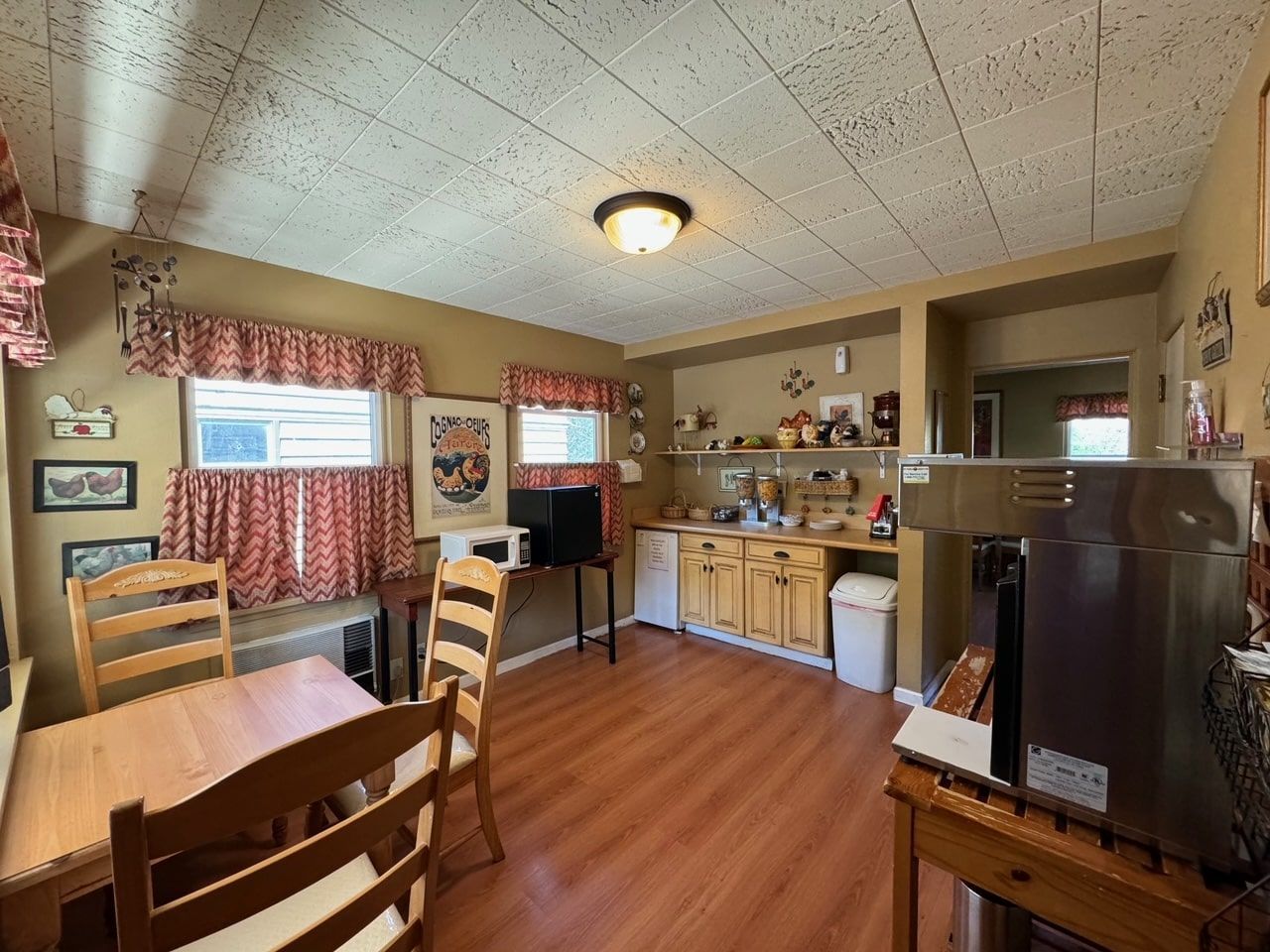 A kitchen with a table and chairs and a microwave.