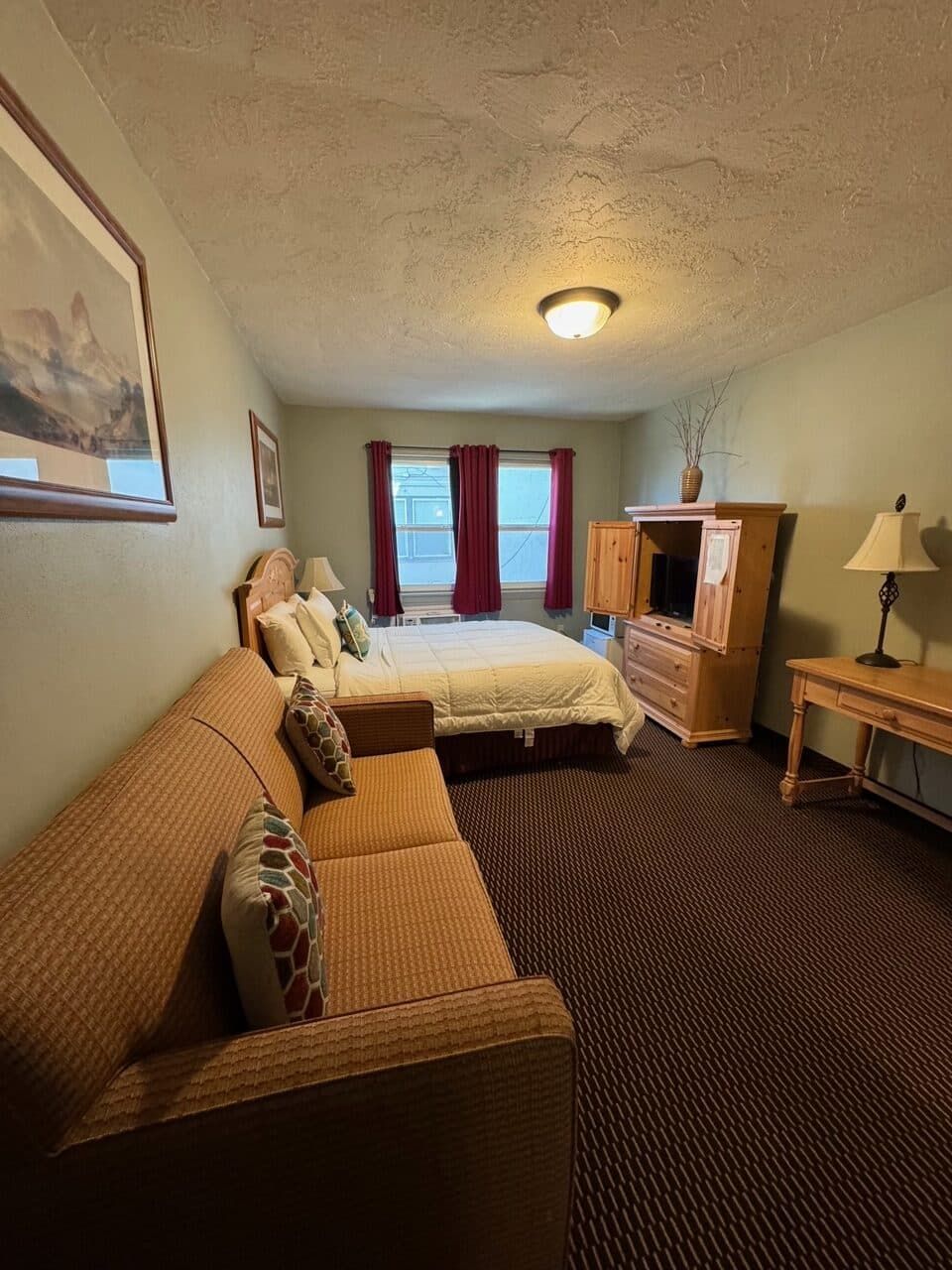 A hotel room with a couch and a bed