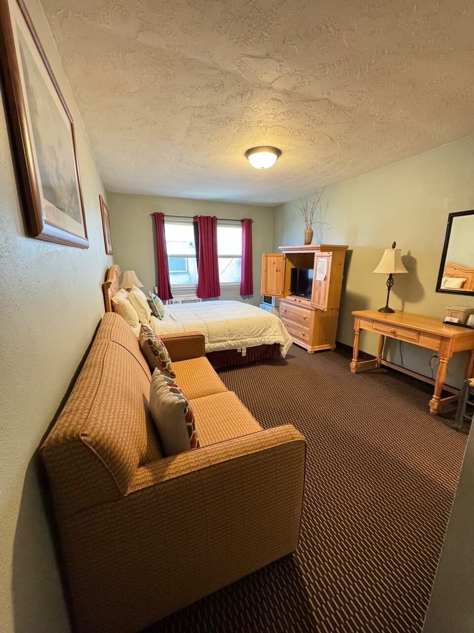 A hotel room with a couch and a bed