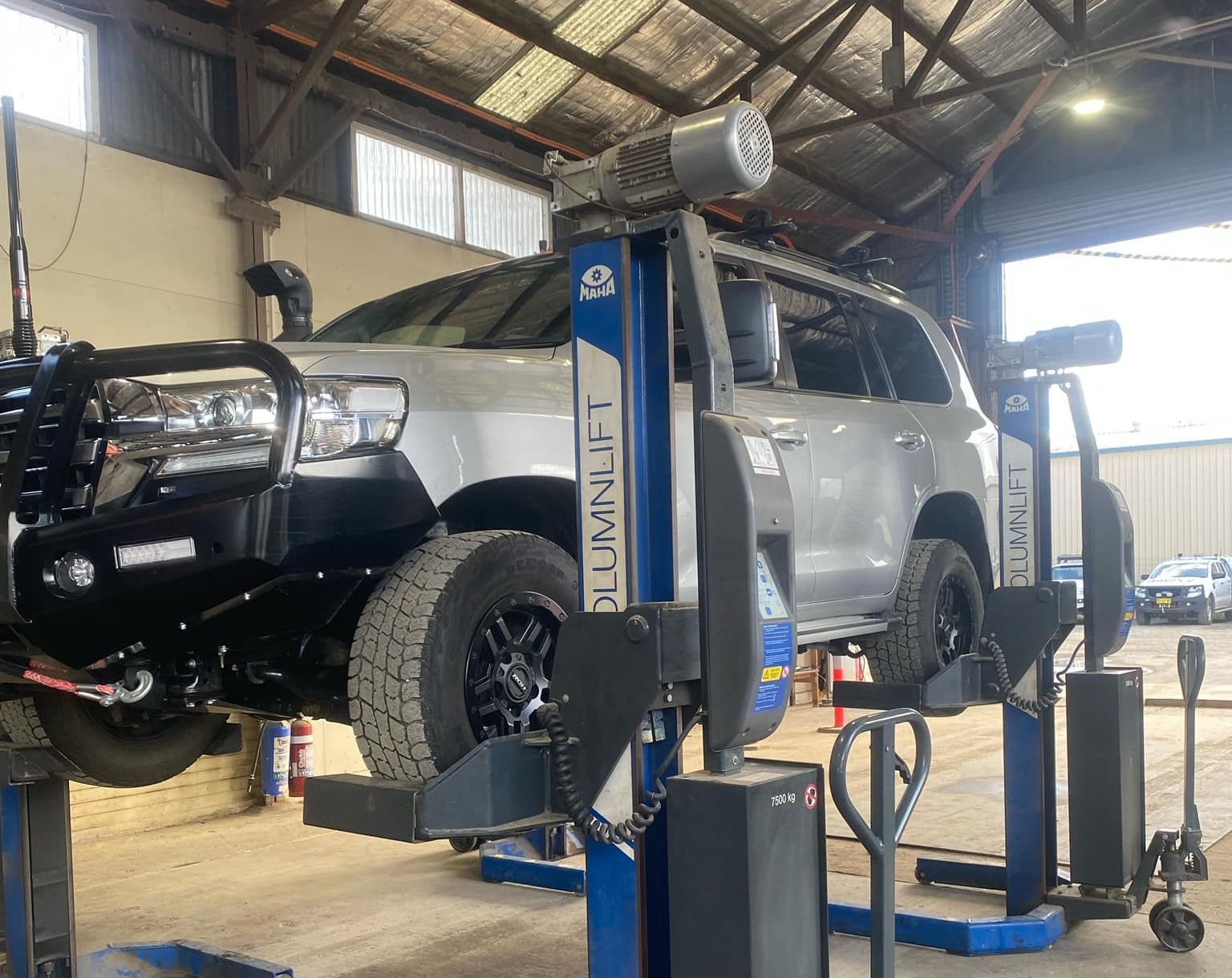 A car is sitting on a lift in a garage. — BDM Heavy Vehicle Repairs In Wauchope, NSW