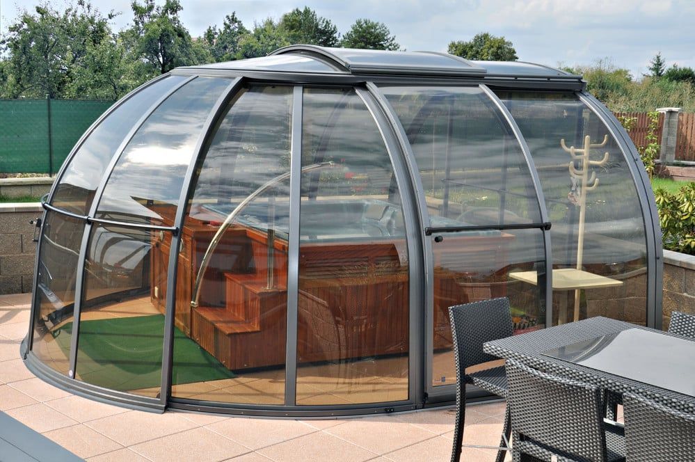 Transparente Kuppelsauna mit Holzbänken auf einer Terrasse im Freien