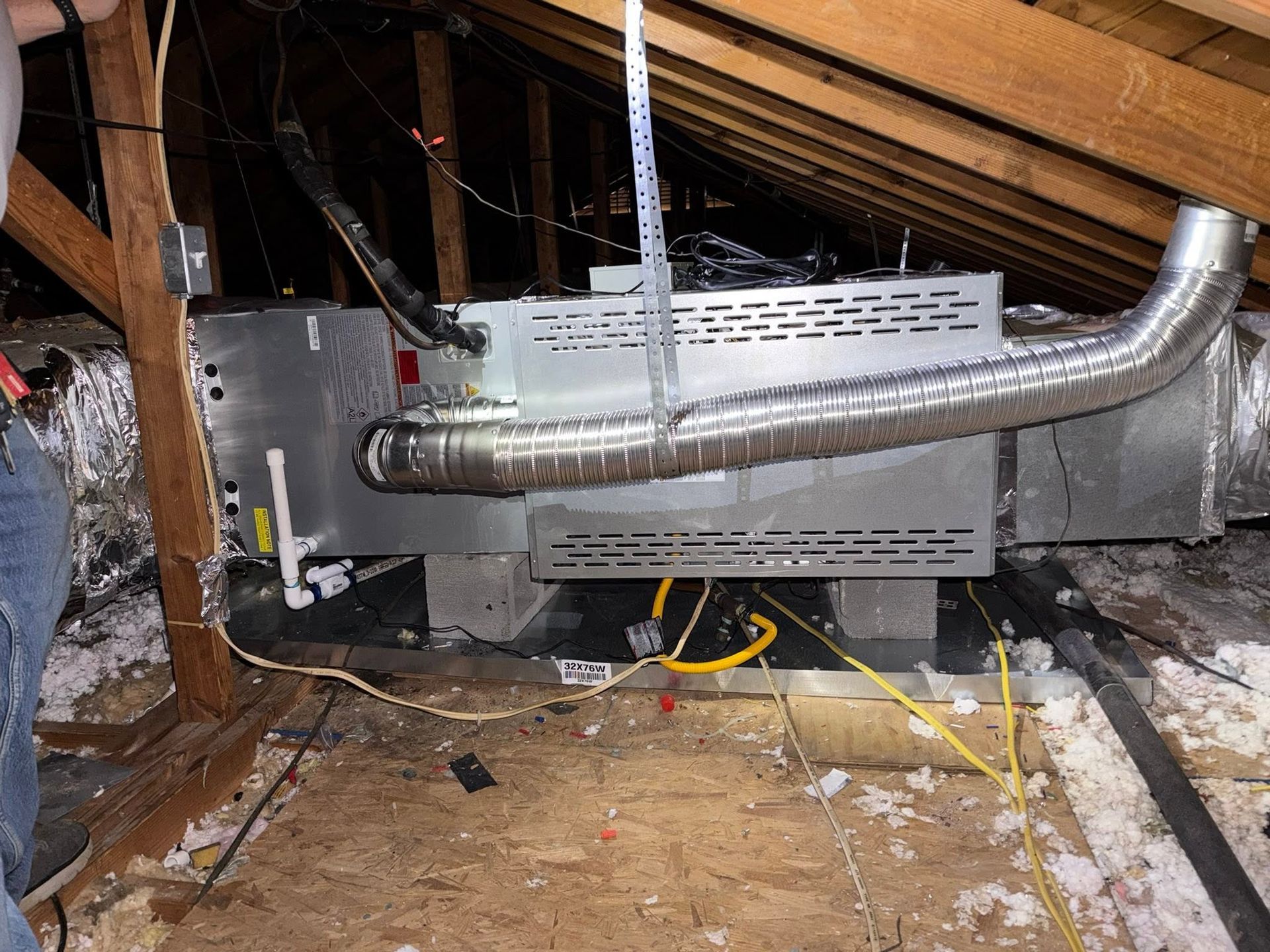 Installed HVAC ductwork and furnace in a crawlspace with exposed insulation and framing