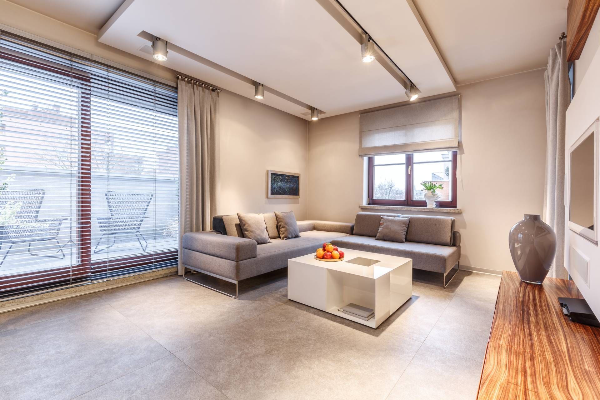 Modern living room with blinds and drapes on a large patio door, leading to outdoor seating near Hou