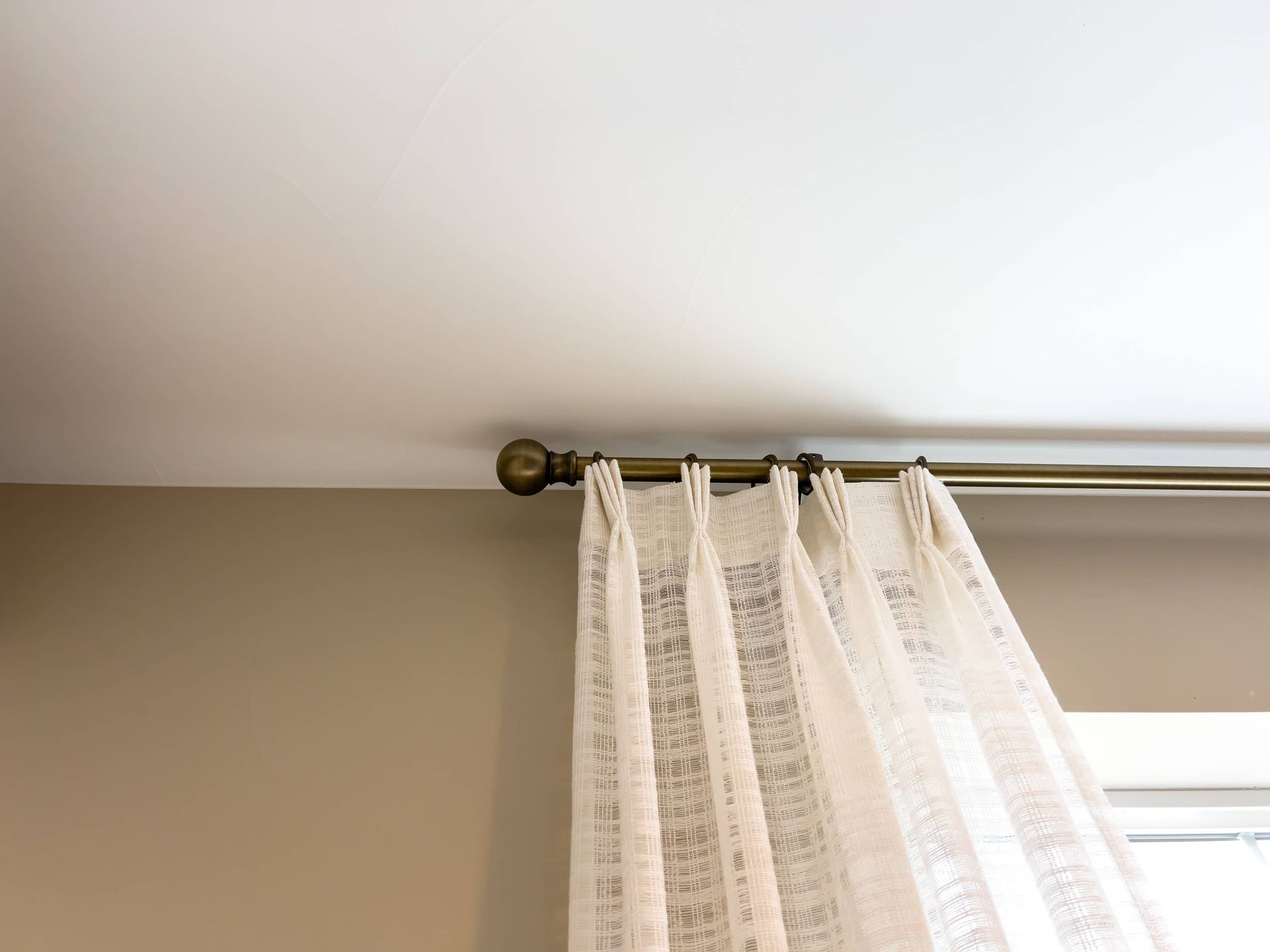 Stunning drapes on a bronzed custom drapery hardware, placed close to the ceiling for added drama n