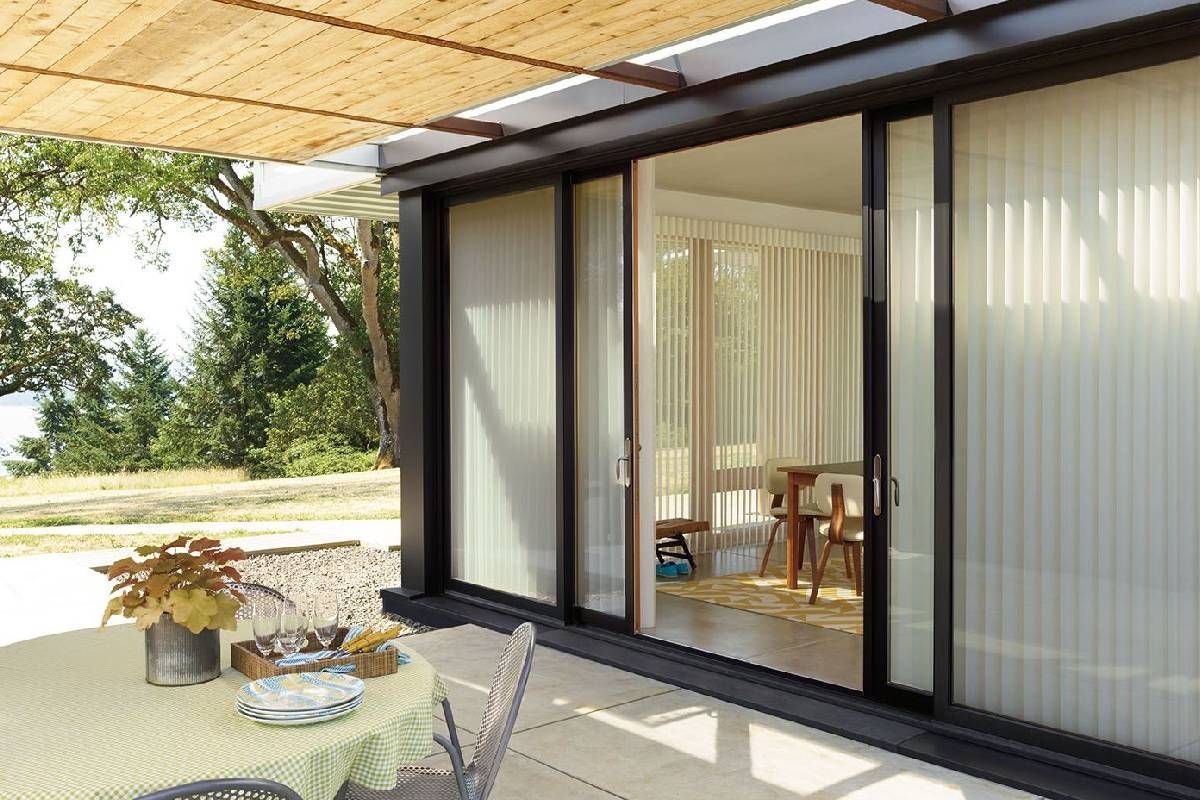 Sliding glass patio doors leading to an outdoor patio dressed with Hunter Douglas Luminette® Sheer Panels at Window Magic Blind & Drapery near Houston, TX