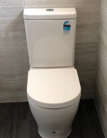 A White, Modern, Floor-Mounted Toilet with A Dual-Flush Button — Port Macquarie Plumbing In Port Macquarie, NSW