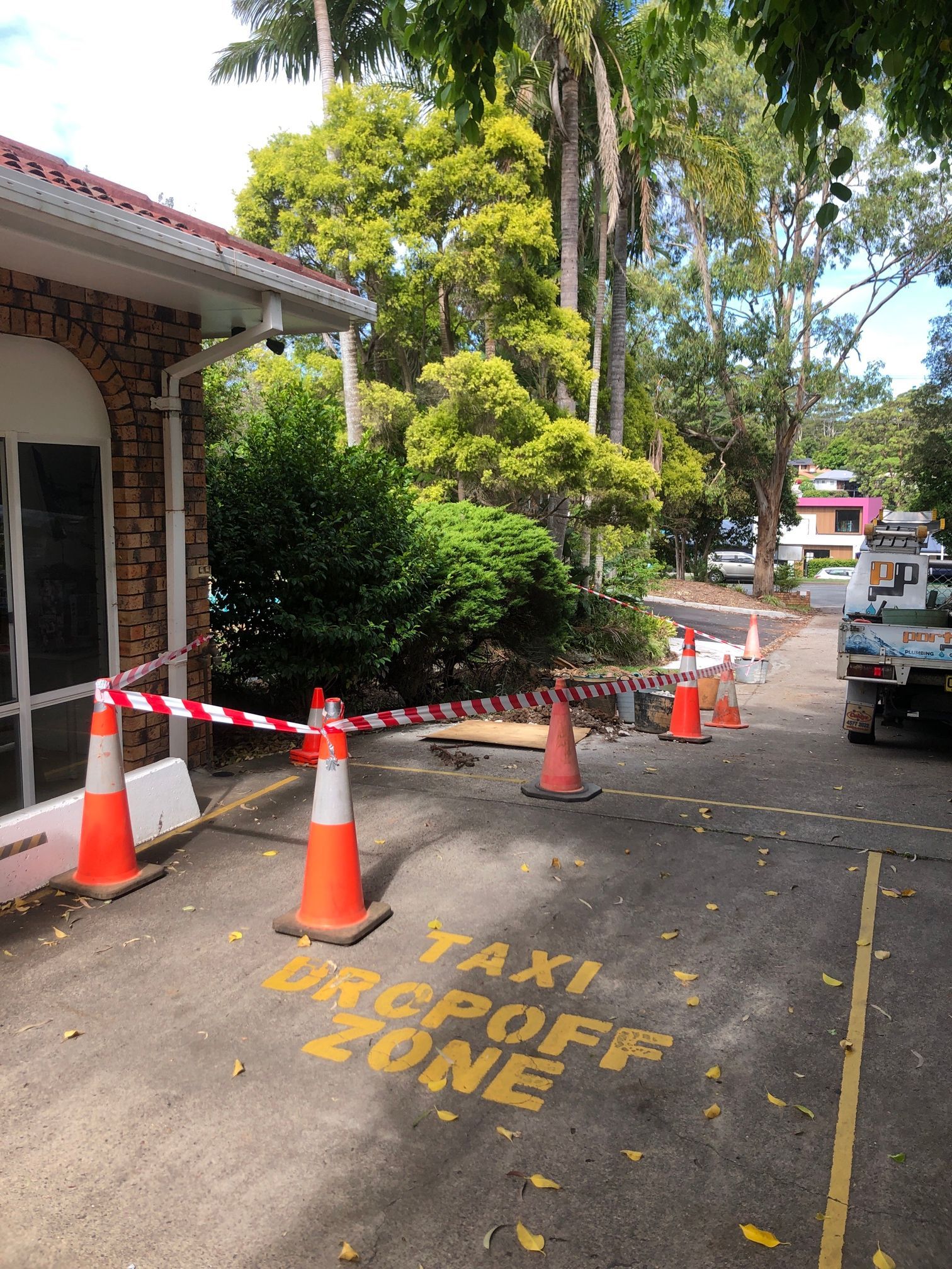 Taxi Drop Off Zone with Orange Cones and Caution Tape Beside a Building — Port Macquarie Plumbing In Port Macquarie, NSW