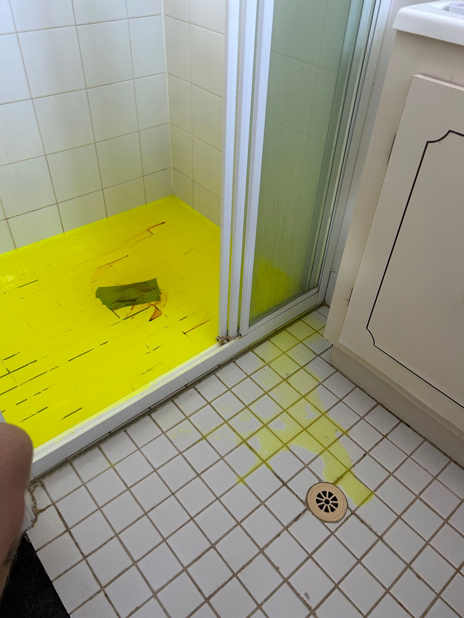 Bathroom with Shower Stall, Bright Yellow Floor, White Tiles, and A Drain on The Floor — Port Macquarie Plumbing In Port Macquarie, NSW