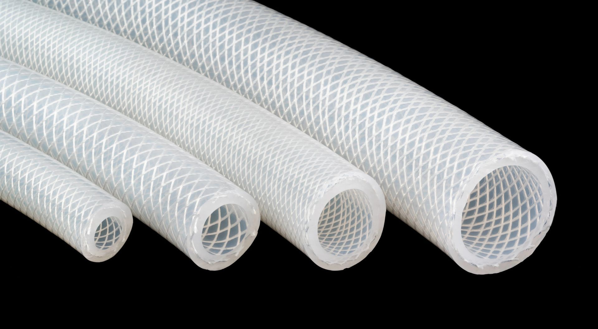 Four white braided mesh hoses of different diameters arranged diagonally on a black background