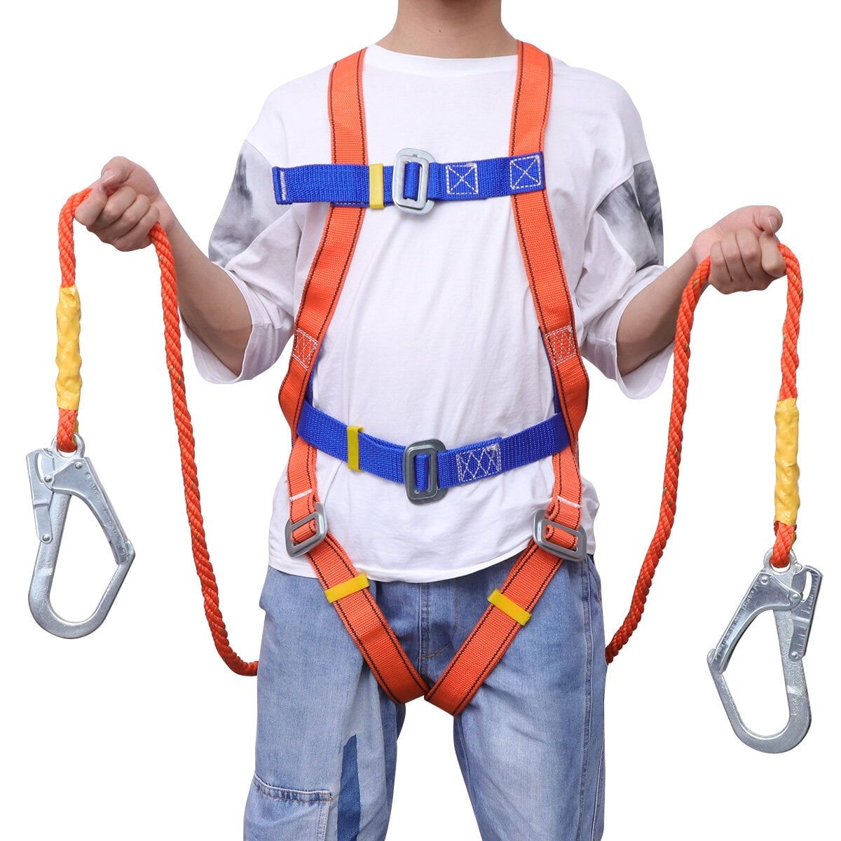 Child wearing an orange safety harness with ropes and clips, standing against a white background