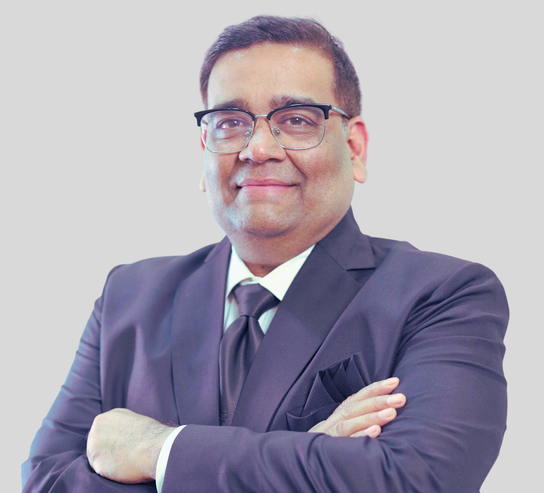 A man in a suit and tie is standing with his arms crossed.