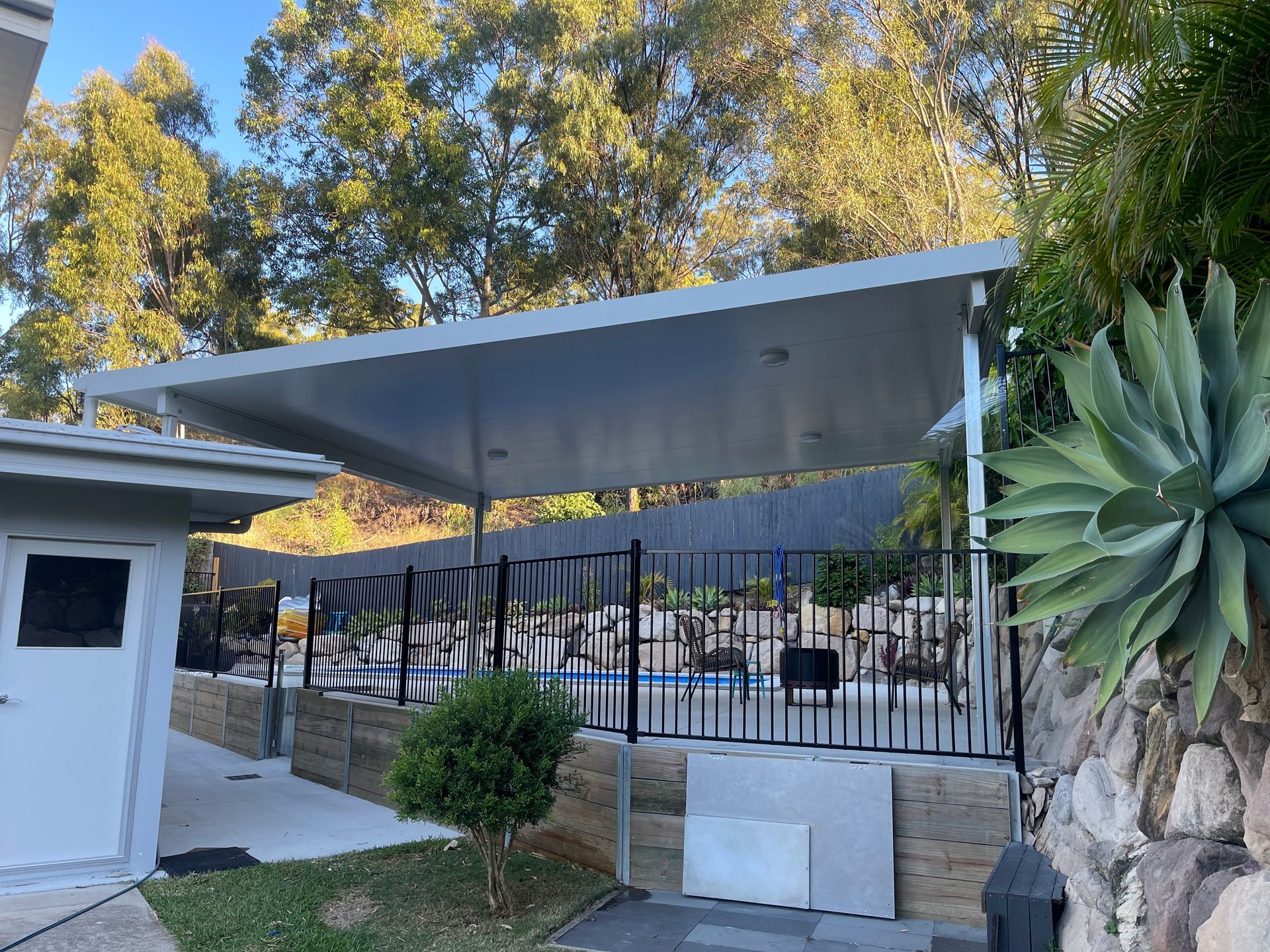 A Patio With A Covered Area And A Fence Around It — AST Steel Constructions in Tannum Sands, QLD