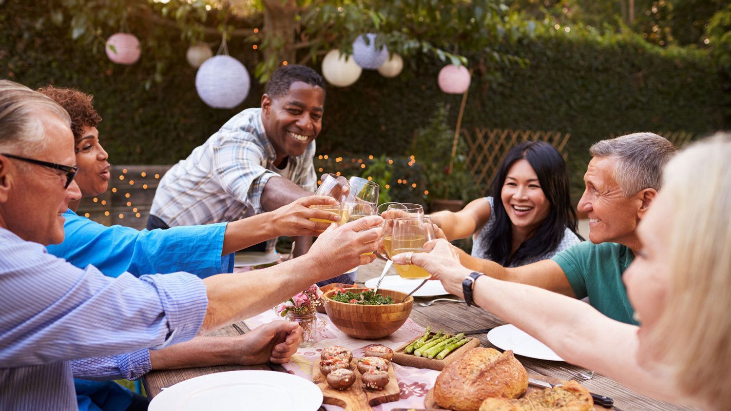 Group toasting at dinner table in a backyard that was pest control treated.
