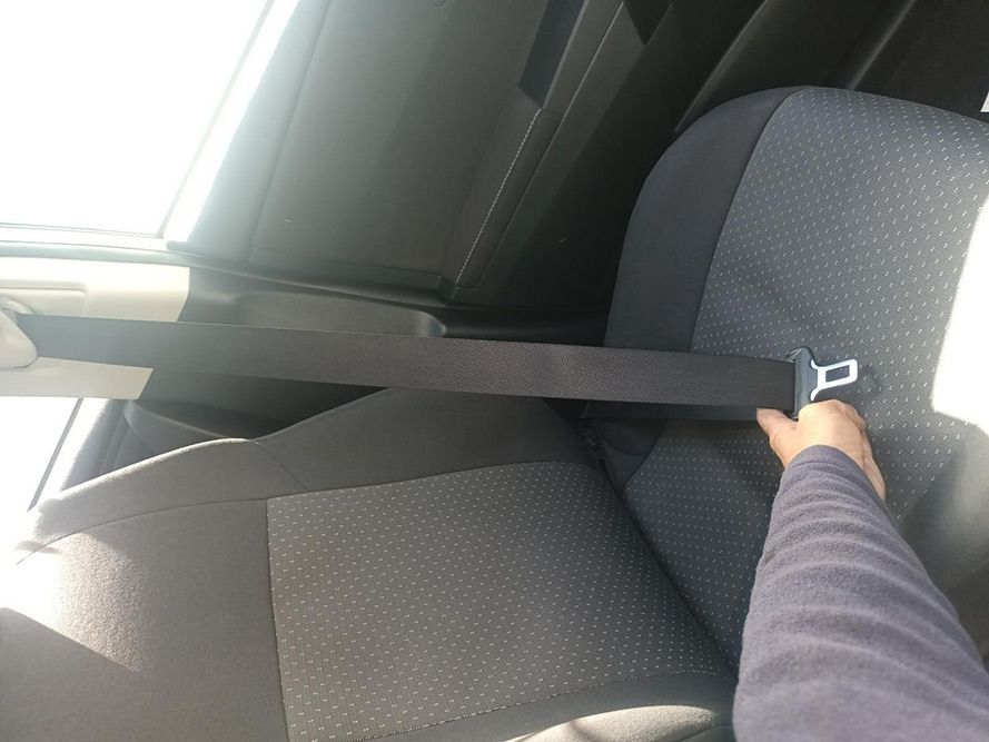 A Person is Putting on a Seat Belt in a Car — South West 4WD Wreckers In Brisbane, QLD