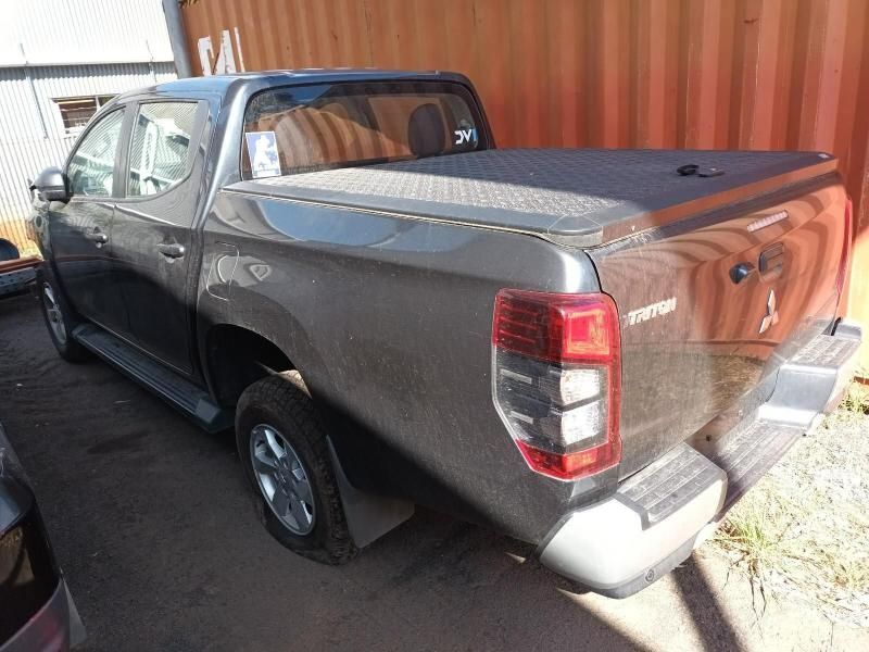 A Gray Truck With a Black Bed Cover is Parked in Front of a Red Container — South West 4WD Wreckers In Brisbane, QLD