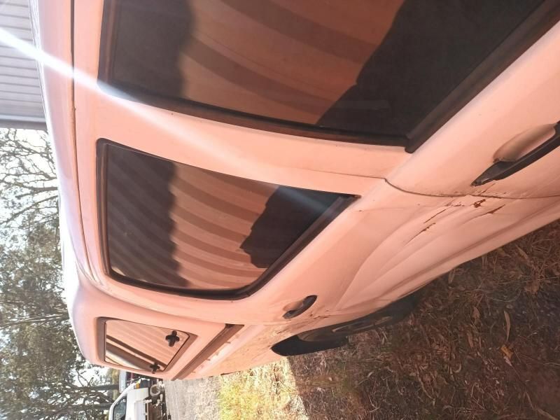 A White Car is Parked on a Dirt Road — South West 4WD Wreckers In Brisbane, QLD