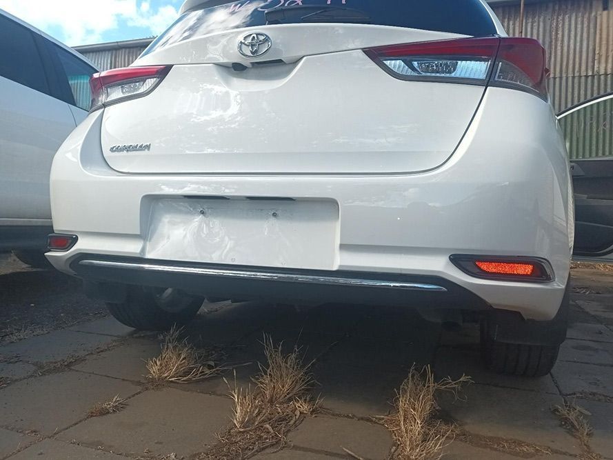 The Rear End of a White Toyota Corolla is Parked in a Parking Lot — South West 4WD Wreckers In Brisbane, QLD