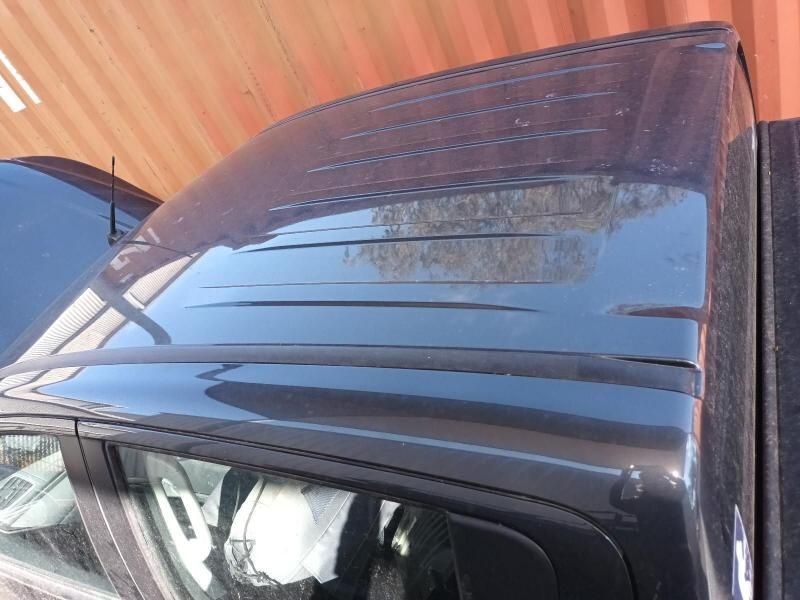 The Roof of a Black Car is Sitting in Front of a Red Wall — South West 4WD Wreckers In Brisbane, QLD