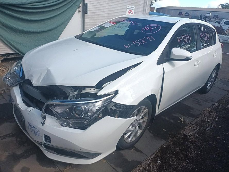 A White Car with a Damaged Front End is Parked on a Sidewalk — South West 4WD Wreckers In Brisbane, QLD