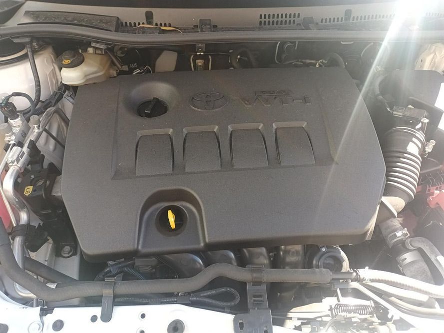 The Engine of a White Toyota Corolla is Visible Under the Hood — South West 4WD Wreckers In Brisbane, QLD
