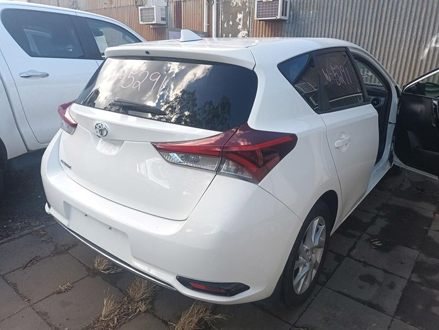A White Toyota Auris Hatchback is Parked in Front of a Building — South West 4WD Wreckers In Brisbane, QLD