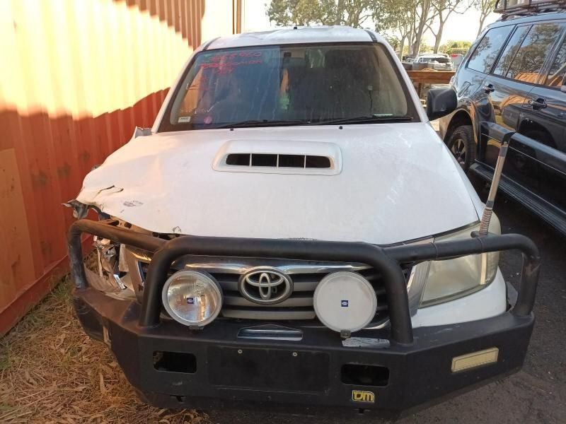 A White Toyota With a Black Bumper is Parked Next to a Red Container — South West 4WD Wreckers In Brisbane, QLD