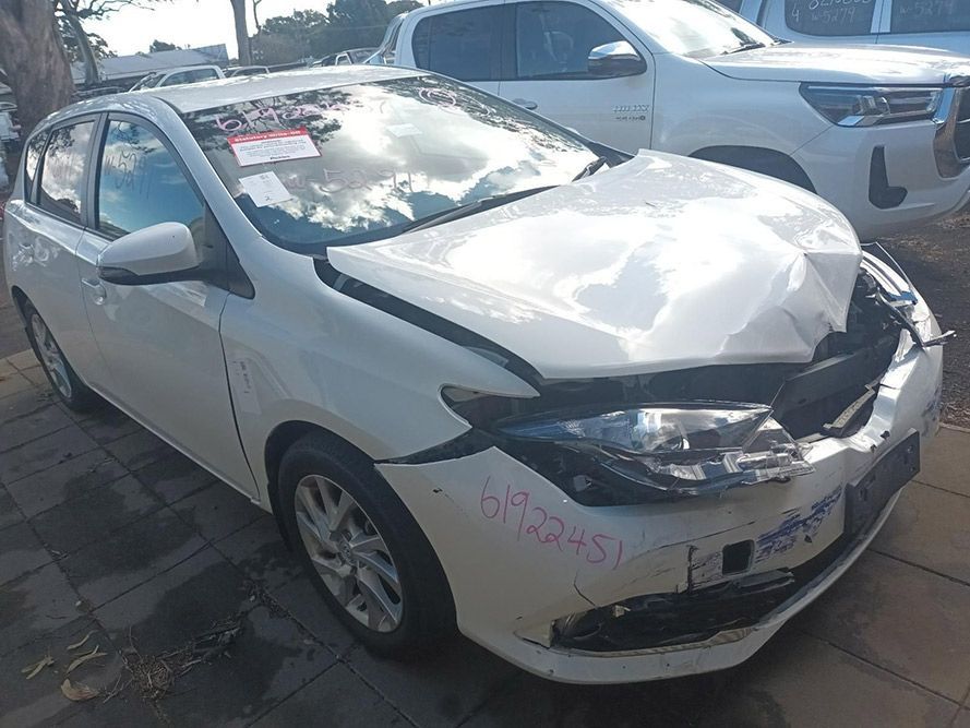 A White Car with a Damaged Front End is Parked on the Side of the Road — South West 4WD Wreckers In Brisbane, QLD