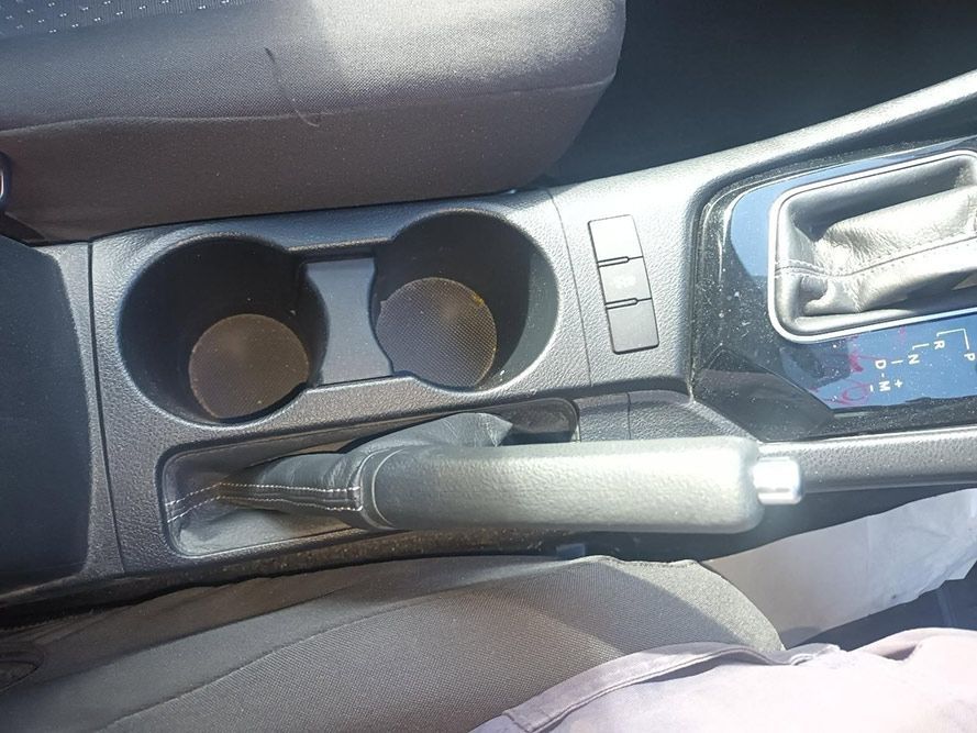 A Person is Sitting in a Car with a Cup Holder and a Handbrake — South West 4WD Wreckers In Brisbane, QLD