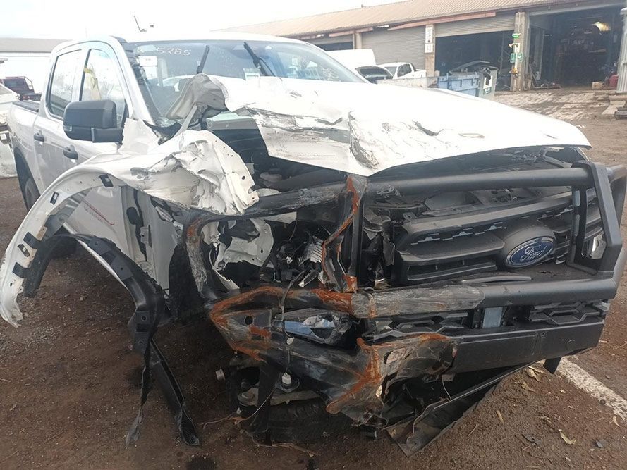A White Truck with a Damaged Front End is Parked in a Parking Lot — South West 4WD Wreckers In Brisbane, QLD