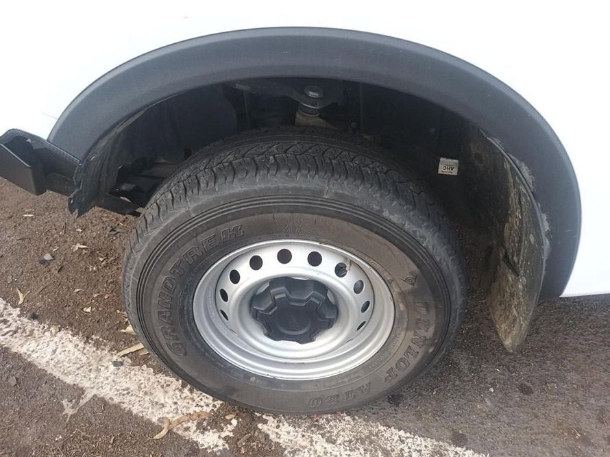A Close Up of a Tire on a White Van in a Parking Lot — South West 4WD Wreckers In Brisbane, QLD