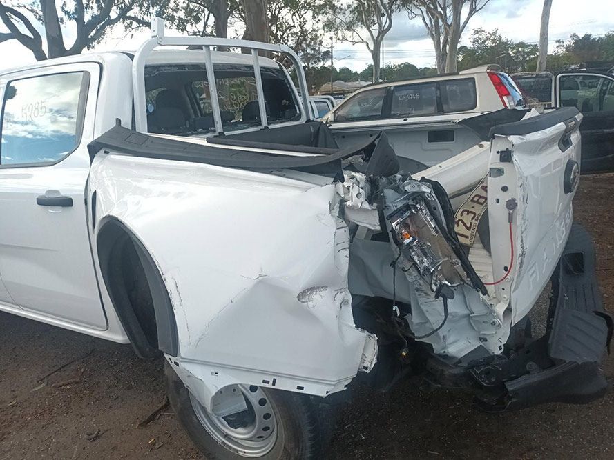 A White Truck with a Damaged Back End is Parked in a Parking Lot — South West 4WD Wreckers In Brisbane, QLD