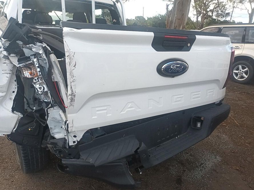 The Back End of a White Ford Ranger Truck is Damaged — South West 4WD Wreckers In Brisbane, QLD