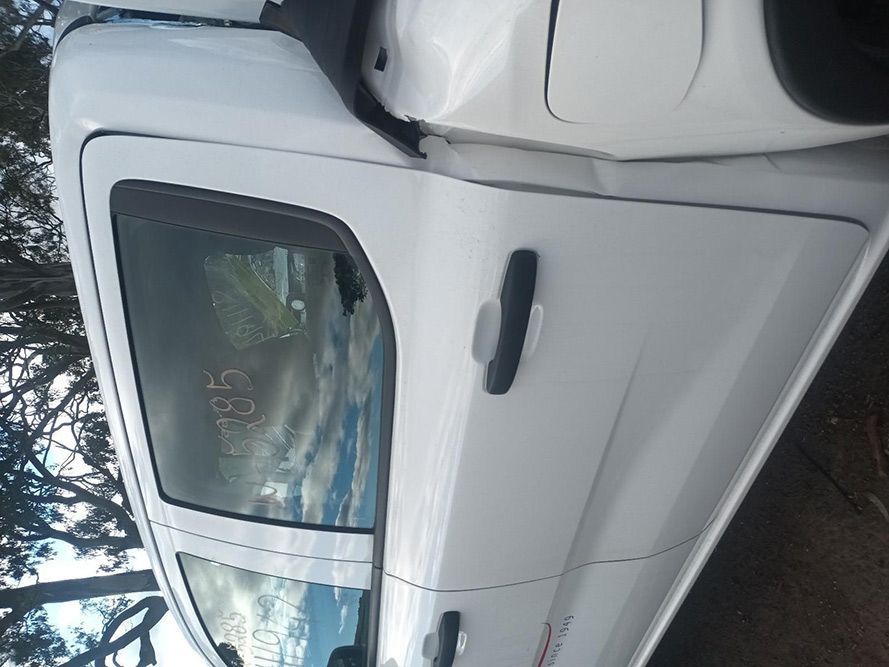 A White Truck with a Damaged Door is Parked on the Side of the Road — South West 4WD Wreckers In Brisbane, QLD