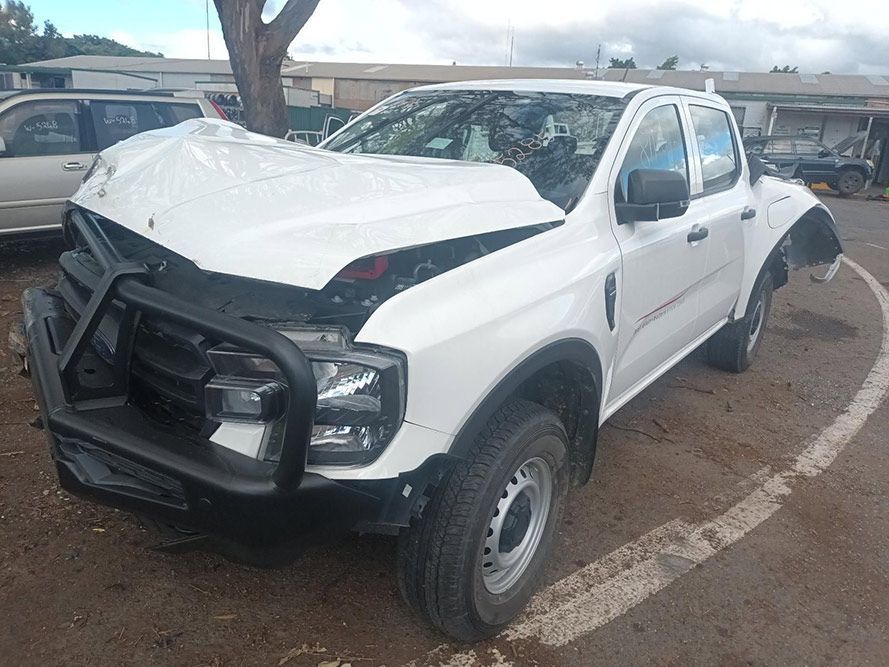 A White Truck with a Damaged Hood is Parked in a Parking Lot — South West 4WD Wreckers In Brisbane, QLD