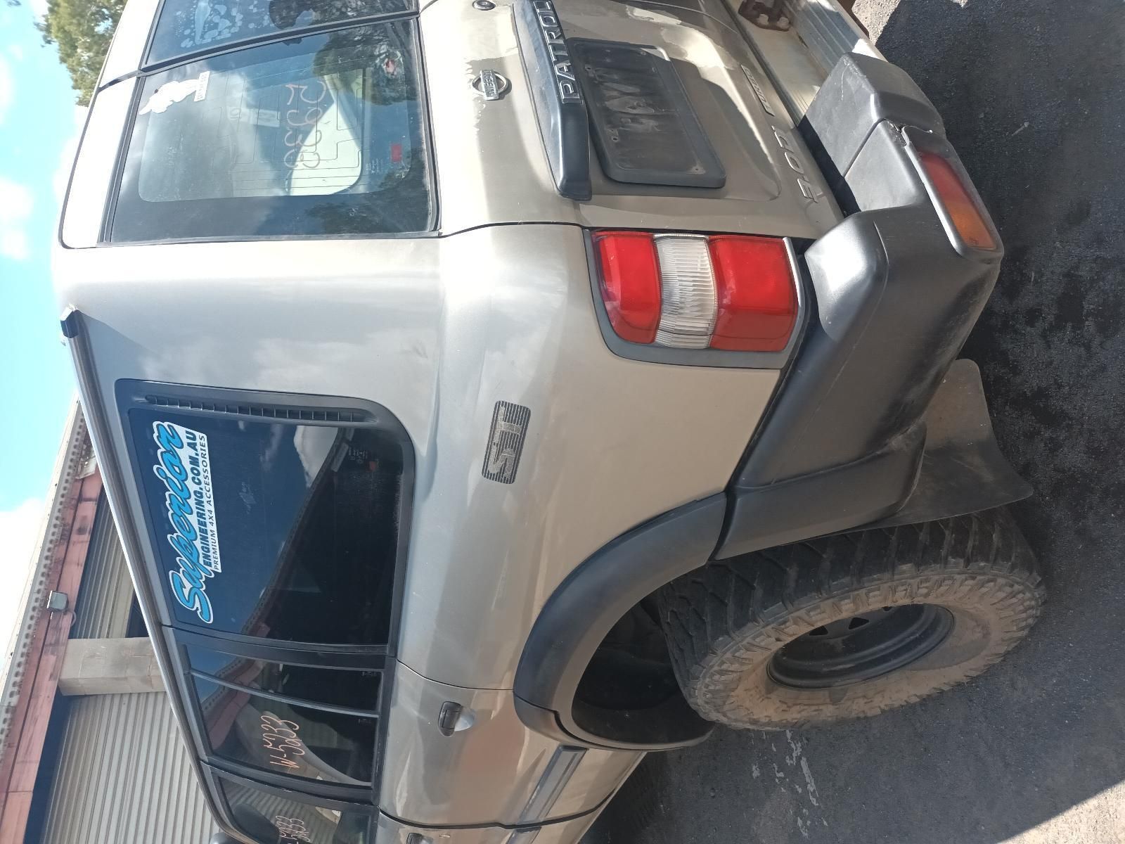 A Silver Nissan Patrol is Parked on the Side of the Road — South West 4WD Wreckers In Brisbane, QLD