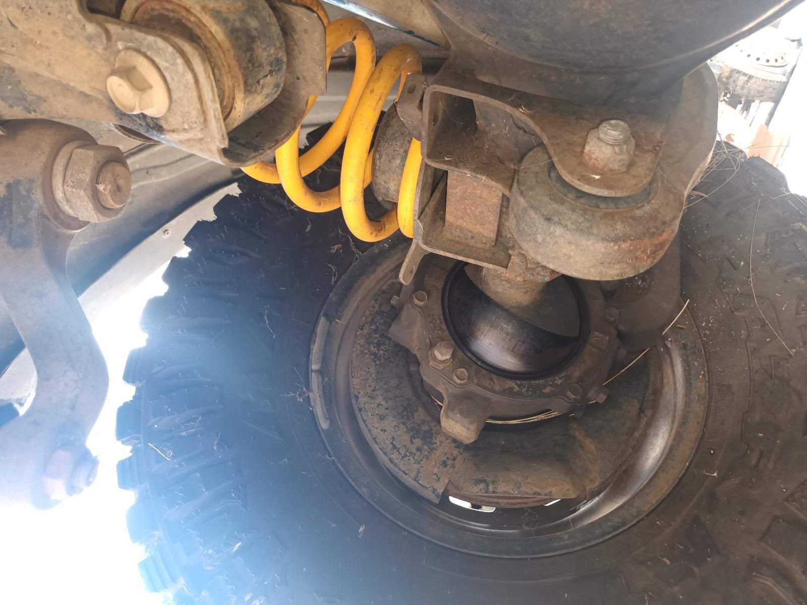 A Close Up of a Tire on a Car with a Yellow Coil Spring Attached to It — South West 4WD Wreckers In Brisbane, QLD