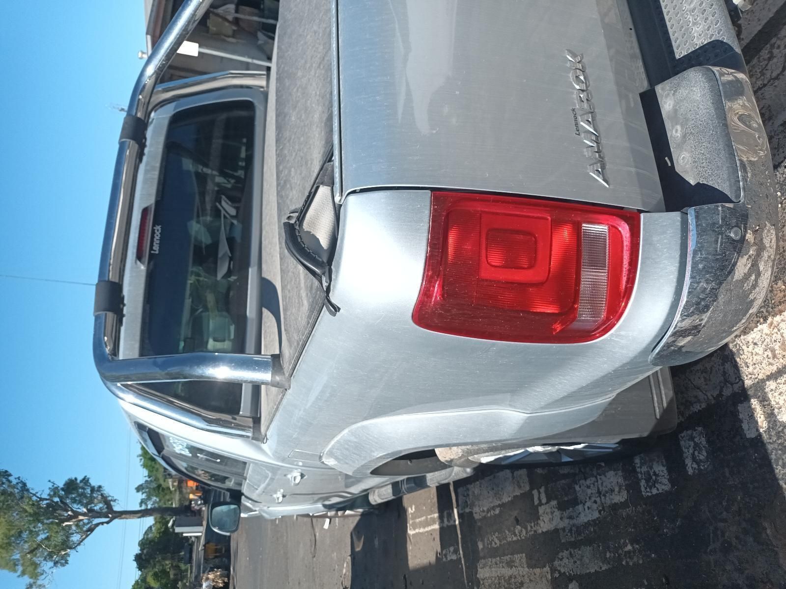 A Silver Pickup Truck with a Red Tail Light is Parked on the Side of the Road — South West 4WD Wreckers In Brisbane, QLD