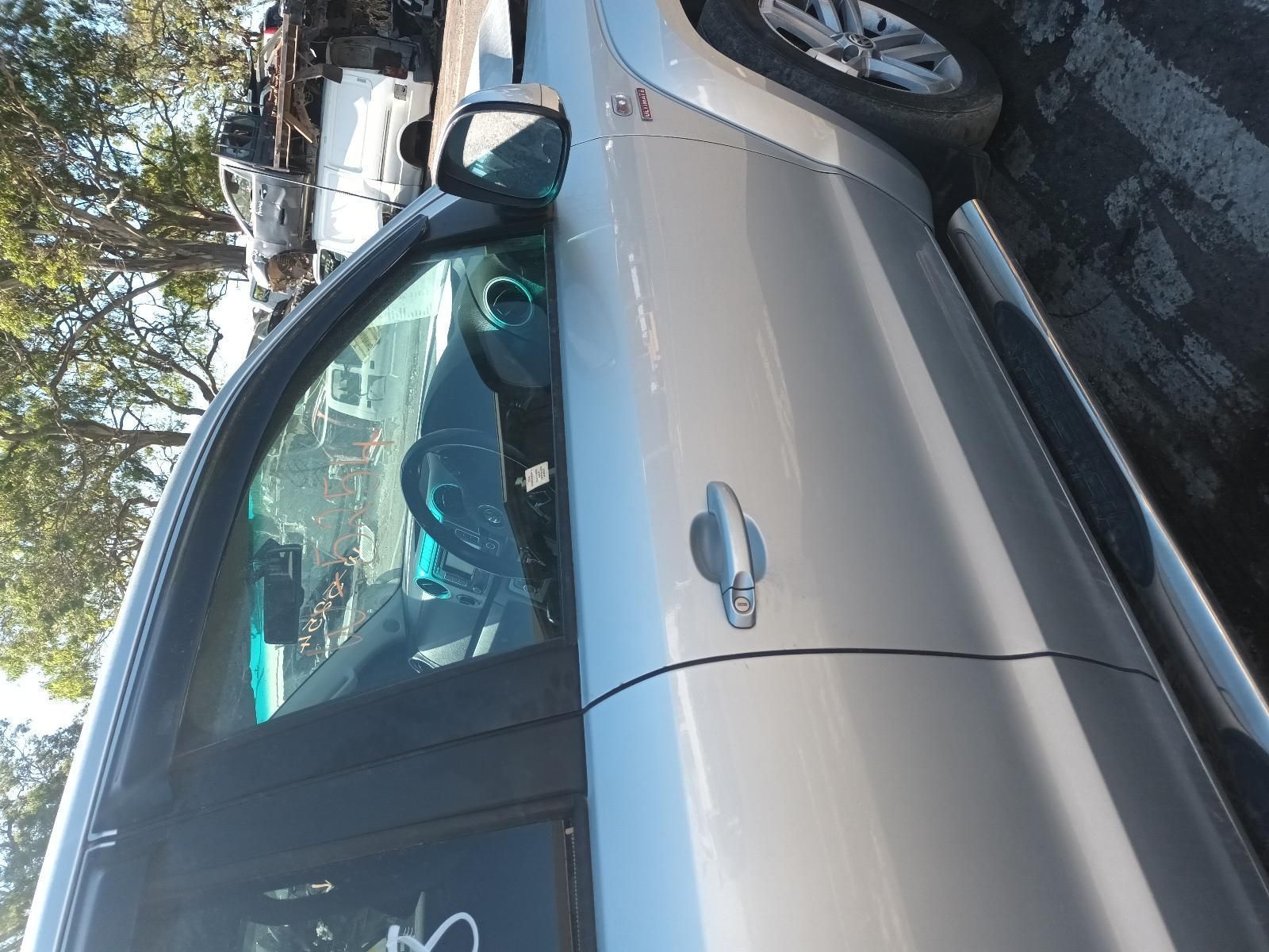 A Silver Car is Parked in a Parking Lot with Trees in the Background — South West 4WD Wreckers In Brisbane, QLD