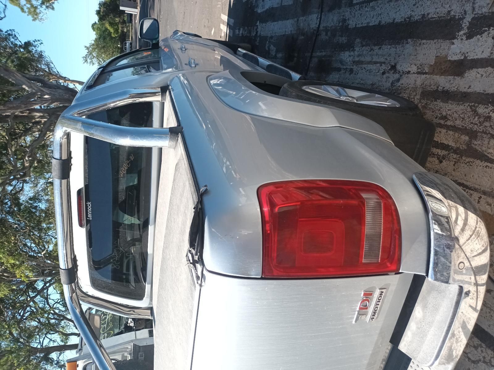 A Silver Truck with a Red Tail Light is Parked on the Side of the Road — South West 4WD Wreckers In Brisbane, QLD