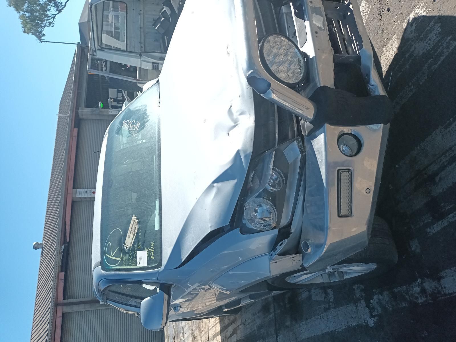 A Damaged Car is Parked in Front of a Building — South West 4WD Wreckers In Brisbane, QLD