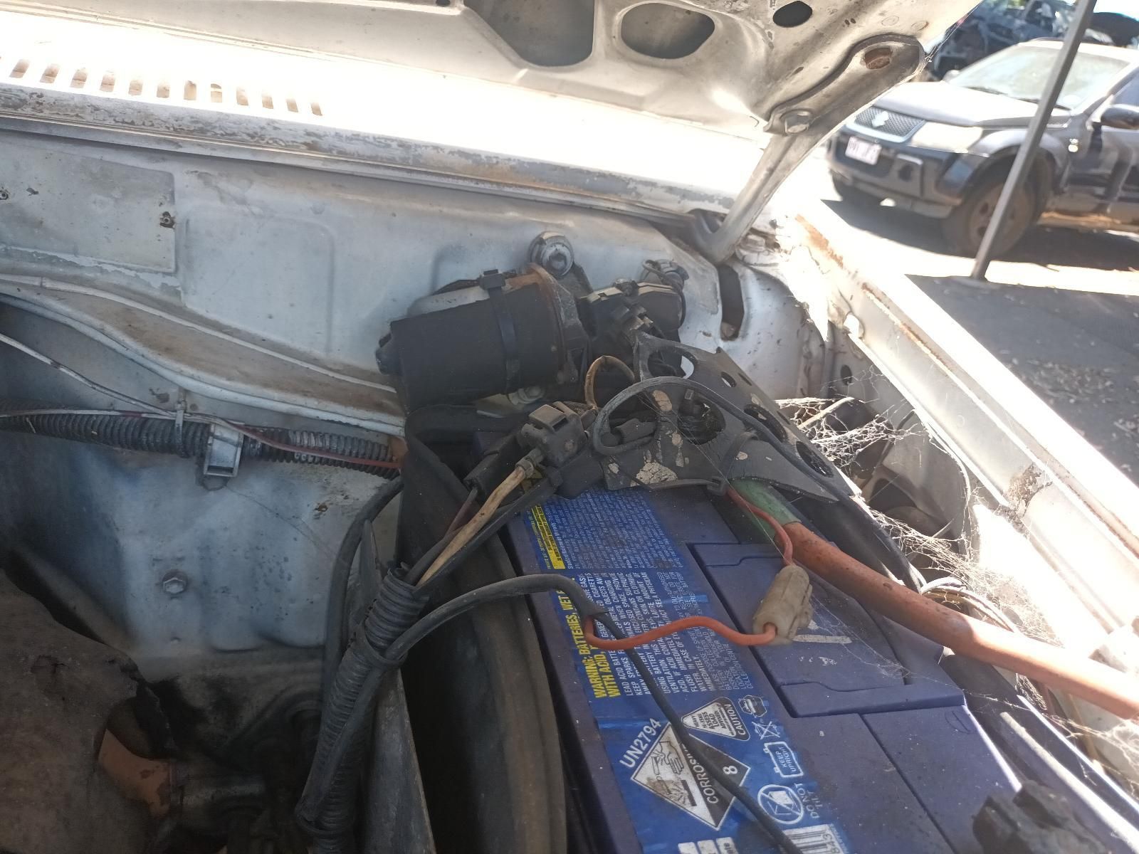 A Blue Battery is Sitting Under the Hood of a Car — South West 4WD Wreckers In Brisbane, QLD