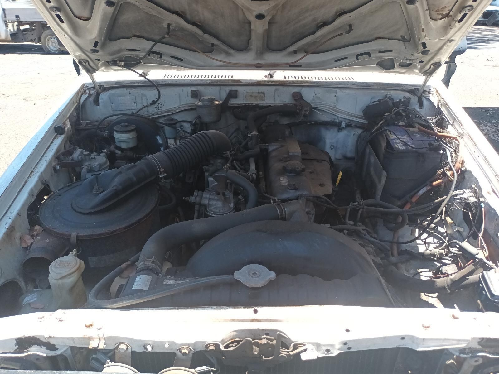 The Engine of a White Car is Shown with the Hood Open — South West 4WD Wreckers In Brisbane, QLD