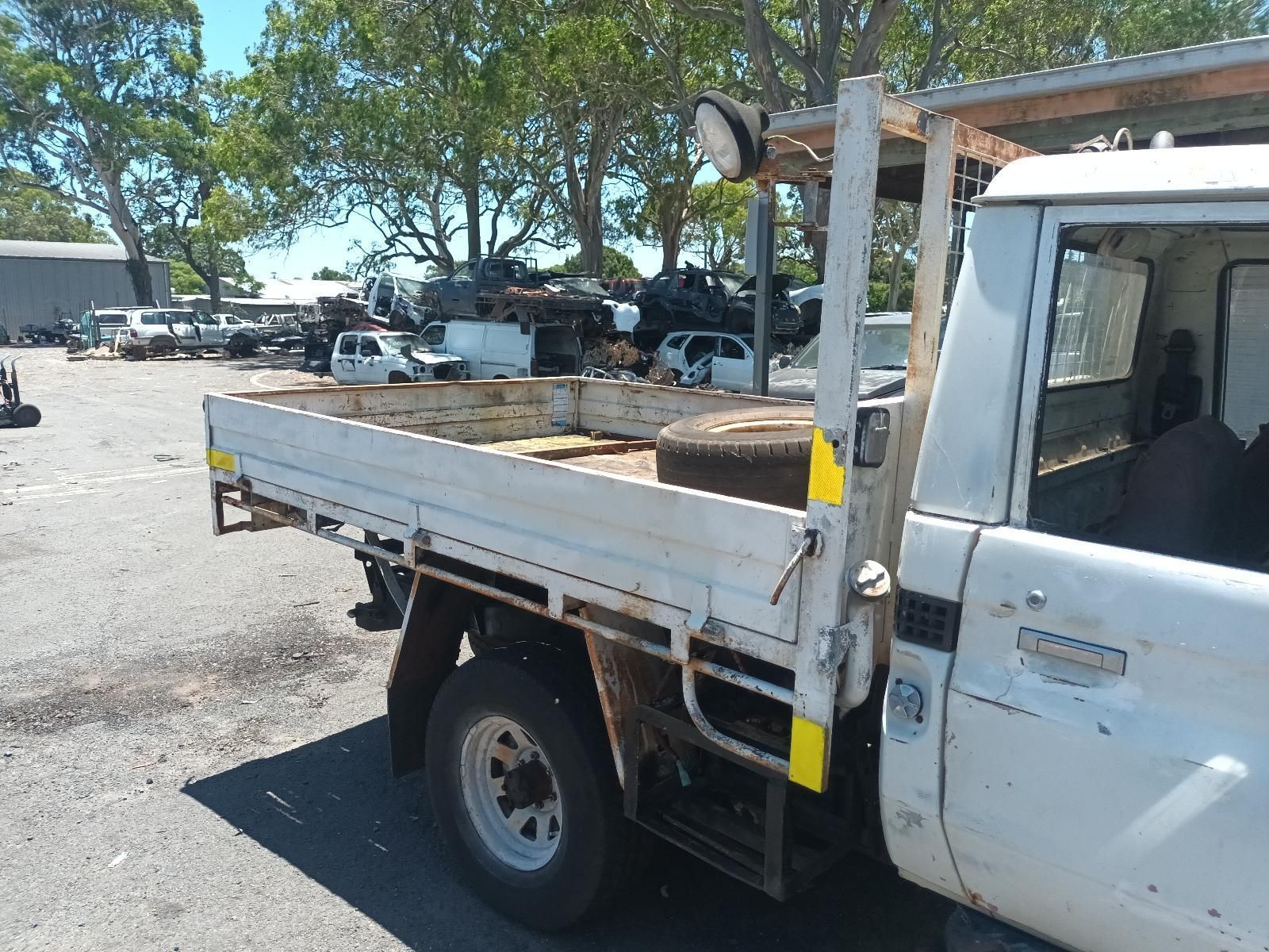 A White Truck with a Flat Bed is Parked in a Parking Lot — South West 4WD Wreckers In Brisbane, QLD
